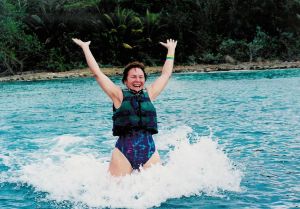 Rita swimming with dolphins, one pushing each food